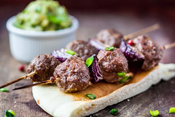 М'ясний шашлик, яловичі кульки на шампурі з цибулею, соус гуакамоле — стокове фото