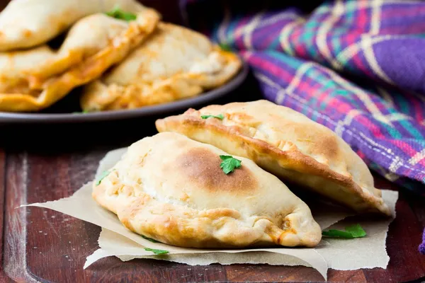 Mini calzone, pizza fechada, pastelaria italiana recheada com queijo — Fotografia de Stock