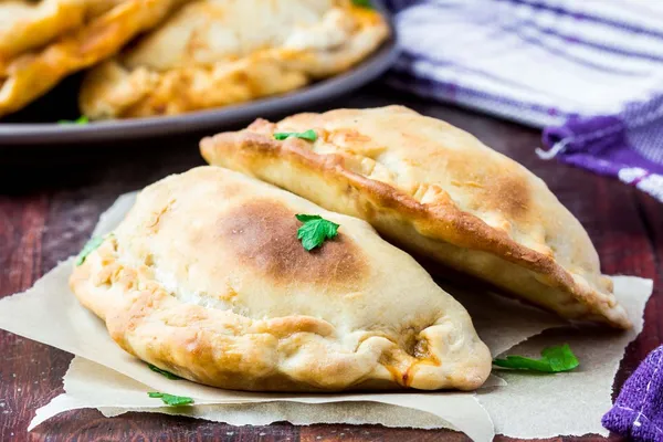 Mini calzone, pizza fechada, pastelaria italiana recheada com queijo — Fotografia de Stock