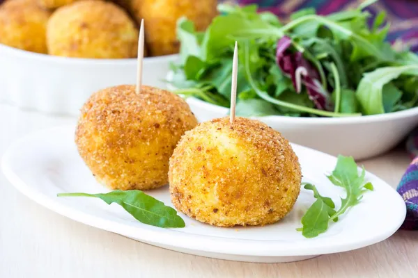 Aperitivo italiano arancini, bolas de arroz rellenas de carne en aceite —  Fotos de Stock