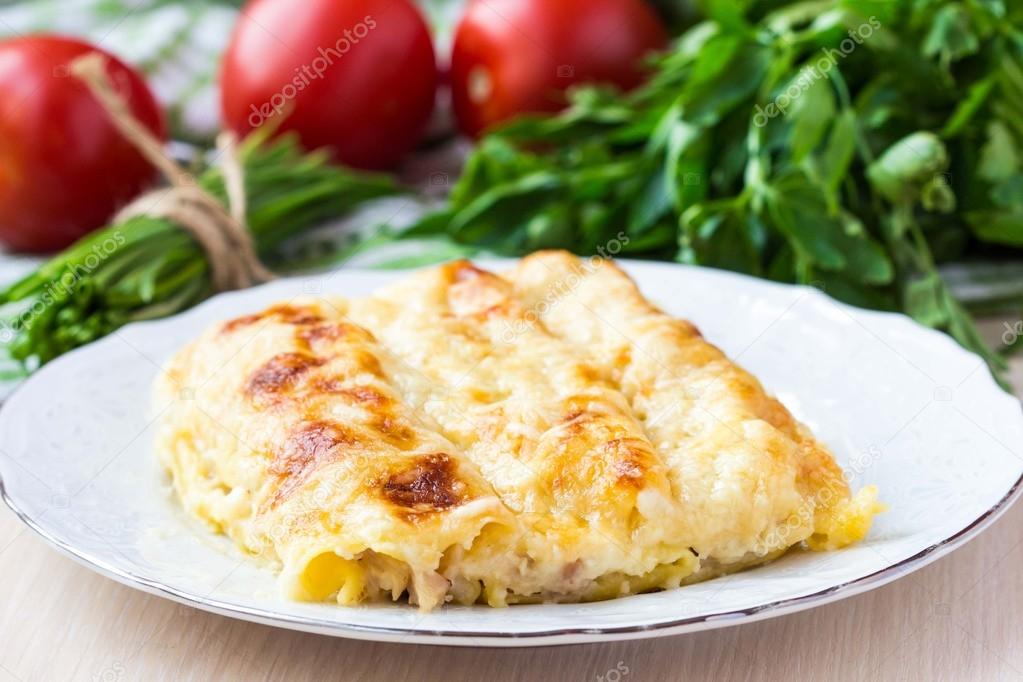 Italian pasta Cannelloni stuffed with meat, white Bechamel sauce