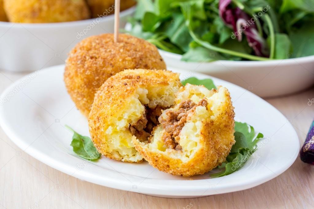 Italian appetizer arancini, rice balls stuffed with meat in oil