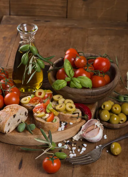 Vers brood met olijven, tomaten, kruiden en olijfolie op een ol — Stockfoto