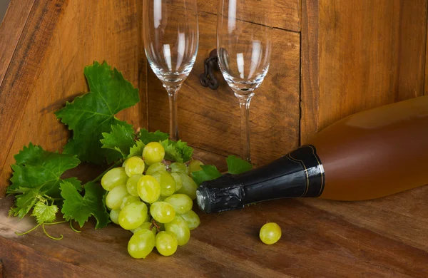 A bottle of wine with a bunch of grapes and wineglasses — Stock Photo, Image