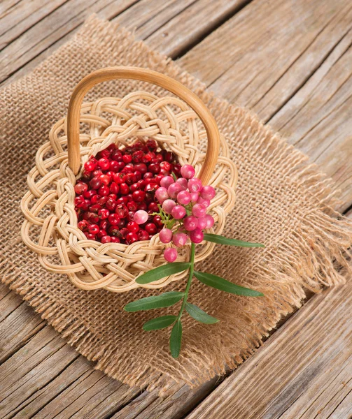 Fresh and dried pink pepper in a small basket — Stock Photo, Image
