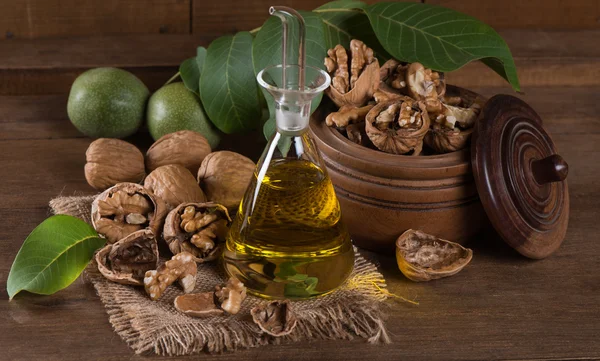 Bottiglia di olio di noce e noci con foglie — Foto Stock