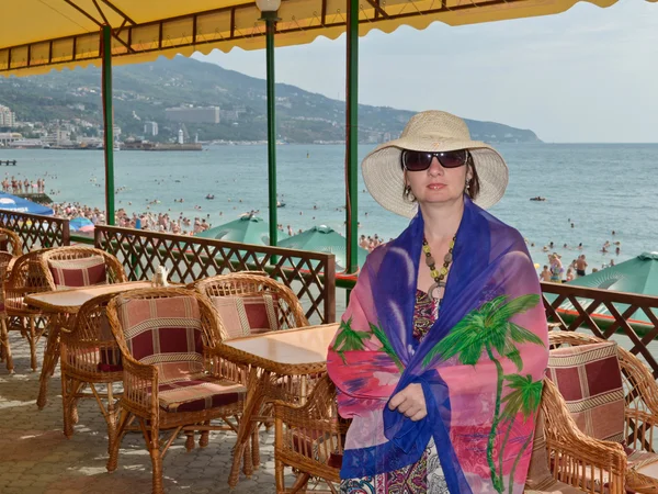 Schöne Frau mit Hut und Brille steht auf einem Hintergrund der Natur — Stockfoto