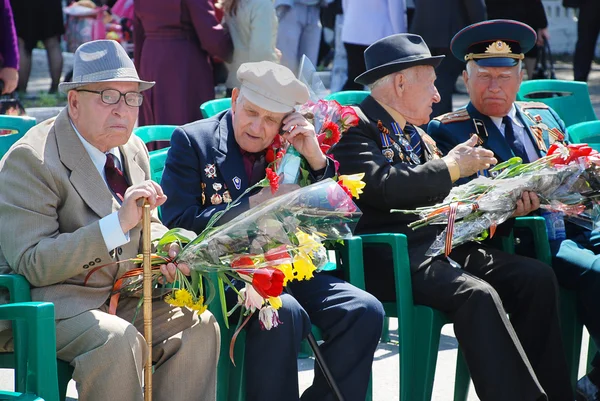 9. května. den vítězství. starší muži, veteráni z války, sedí s medailí a květiny — Stock fotografie