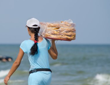 kadın bir tepsi baklava giyer