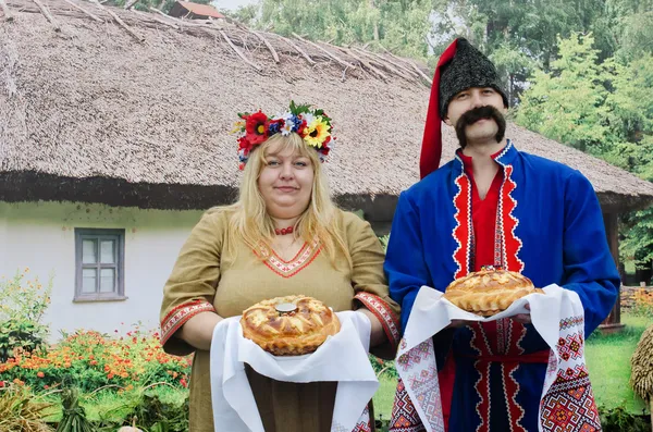 Ucranianos - un hombre y una mujer, saludaron a los invitados con pan y sal — Foto de Stock