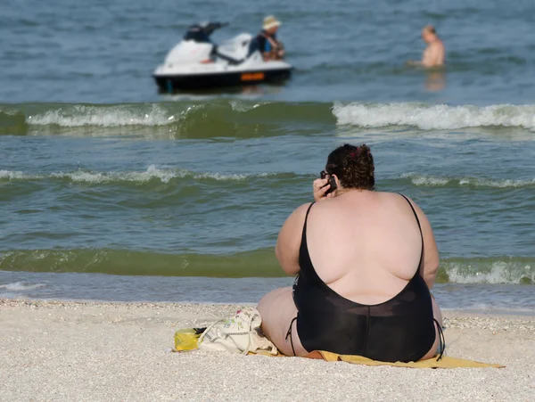 Fet kvinna på stranden — Stockfoto