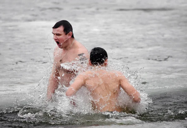Fête religieuse chrétienne Épiphanie. Les gens se baignent dans la rivière en hiver  . — Photo