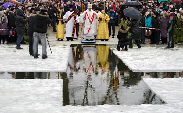 Fiesta cristiana religiosa de la Epifanía. Sacerdote, el obispo bendice el agua y la gente — Foto de Stock