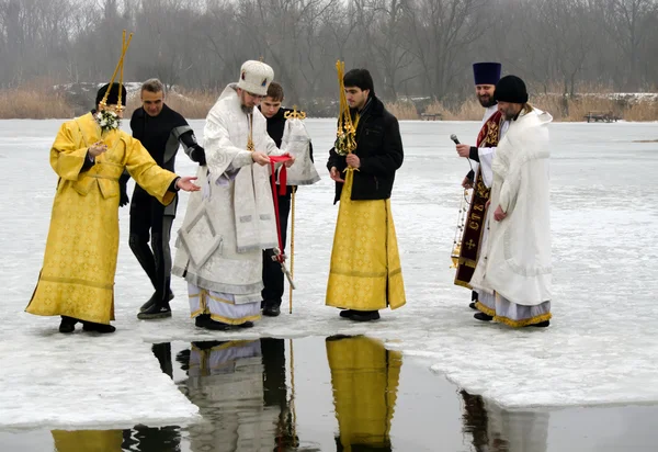 Fiesta cristiana religiosa de la Epifanía. Sacerdote, el obispo bendice el agua y la gente —  Fotos de Stock