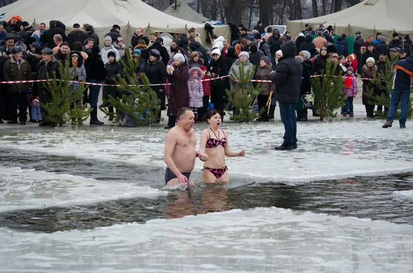 Mensen Baden in de rivier in de winter. christelijke religieuze festival epiphany — Stockfoto