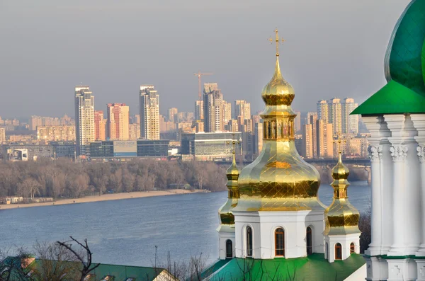 Kiev - Pechersk Lavra.Cupola d'oro della chiesa sullo sfondo del fiume Dnieper e degli edifici — Foto Stock