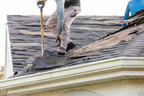 roofer removing roof shingles with roof shingle remover