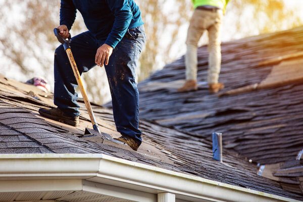 roofer removing roof shingles with roof shingle remover