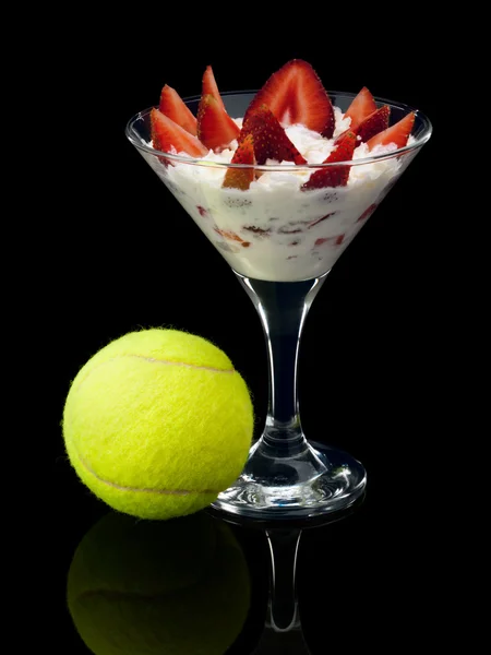Strawberry with cream and a tennis ball. — Stock Photo, Image