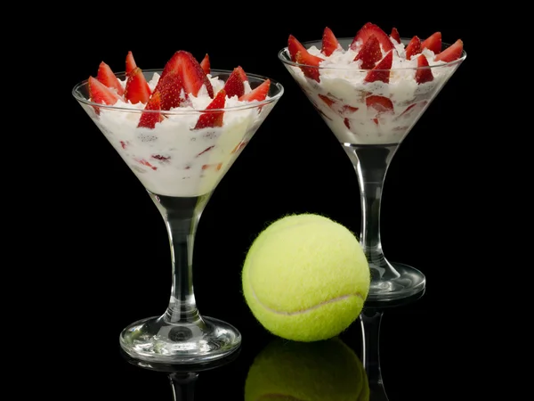 Tennis ball and strawberry with cream in two glasses. — Stock Photo, Image
