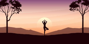 Yogacı kız büyük ağaçlar ve gün batımında dağ manzaralı güzel bir manzara.