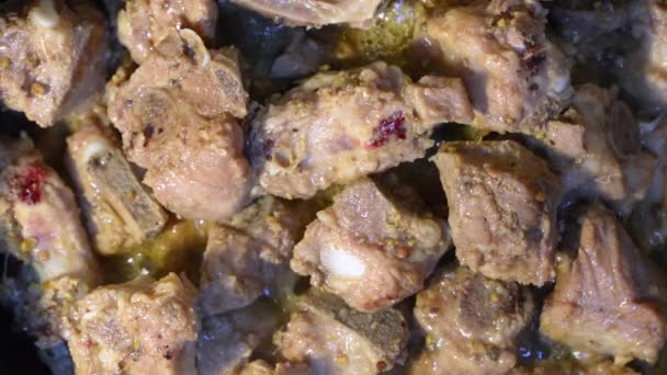 鉄板鍋で焼き豚カルビで揚げたおいしいを閉じます ニンニクとコショウでマリネ豚カルビ スパイスの香りと柔らかい豚肉 — ストック動画