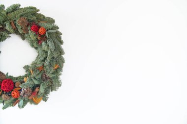 Doğal köknar dallarından yapılmış çelenkler doğal süslemelerle asılıdır: tümsekler, koniler, çelenkler, yıldızlar. Noel Tatili Çelengi Beyaz Arkaplanda İzole Edildi.