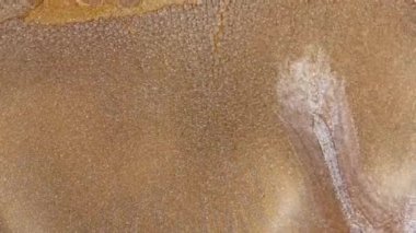 Grunge arka planı erimiş altın, bronz, bakır. Makro video parıltılı sıvı hareketi. Işıl ışıl sarı mürekkep boyası. Metalik su, fantastik okyanus dalgaları. Güzel sıvı sanat. Yüksek kalite