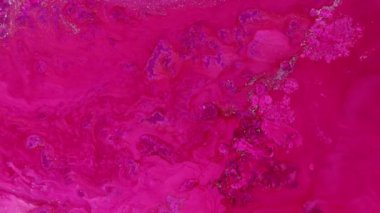 Soyut sıvı sanat arka planı, parlak parlak pembe su dalgaları. Parlak altın ve yanardöner inci parçacıklarının fuşya alkollü mürekkep boyasında akışının makro videosu. Yüksek kalite