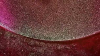 Meditasyon amaçlı, yuvarlak, akışkan sanat arka planı. Pembe arka planda parlak altın rengi boya akışı. Yarıçap boyunca mürekkep taşmış. Dönen toz zerreleri. Şelale illüzyonu. Yüksek kaliteli makro video