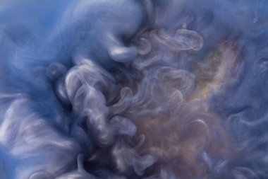 Suya gerçek boya damlaları düşer. Mavi arkaplanda soyut mavi mürekkep bulutu çarpışması izole edildi. Sıvı mermer deseni. Modern sanat. Soyut akrilik resim.