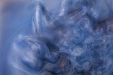 Suya gerçek boya damlaları düşer. Mavi arkaplanda soyut mavi mürekkep bulutu çarpışması izole edildi. Sıvı mermer deseni. Modern sanat. Soyut akrilik resim.