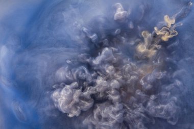 Suya gerçek boya damlaları düşer. Mavi arkaplanda soyut mavi mürekkep bulutu çarpışması izole edildi. Sıvı mermer deseni. Modern sanat. Soyut akrilik resim.