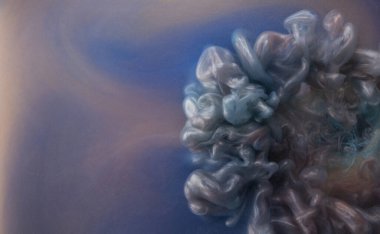 Suya gerçek boya damlaları düşer. Soyut mor mürekkep bulutu çarpışması mavi arka planda izole edildi. Sıvı mermer deseni. Modern sanat. Soyut akrilik resim.