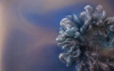 Suya gerçek boya damlaları düşer. Soyut mor mürekkep bulutu çarpışması mavi arka planda izole edildi. Sıvı mermer deseni. Modern sanat. Soyut akrilik resim.