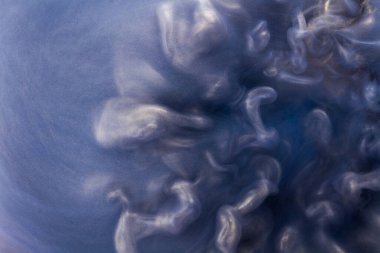 Suya gerçek boya damlaları düşer. Mavi arkaplanda soyut mavi mürekkep bulutu çarpışması izole edildi. Sıvı mermer deseni. Modern sanat. Soyut akrilik resim.