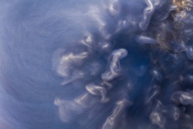 Suya gerçek boya damlaları düşer. Mavi arkaplanda soyut mavi mürekkep bulutu çarpışması izole edildi. Sıvı mermer deseni. Modern sanat. Soyut akrilik resim.