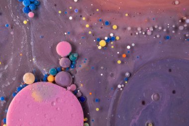 Mor, mavi, pembe ve sarı sıvılar karışımı. Yaratıcı çok renkli arkaplan. Akrilik boya topları soyut doku. Parlak renk sıvısı, akan duvar kağıdı tasarımı. Karışık pigmentler menekşe arkaplan.