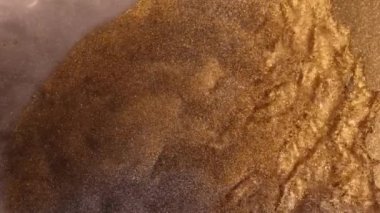 Altın tozu parçacıkları havada yavaş çekimde uçar ve yavaşça kalır. Toz Parçacıkları. Kar tanecikleri. Yüksek kalite 4k görüntü.