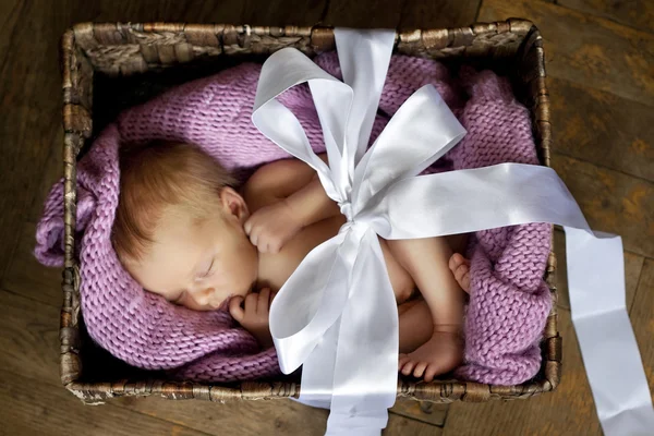 Little cute baby in the box with a gift bow — Stock Photo, Image