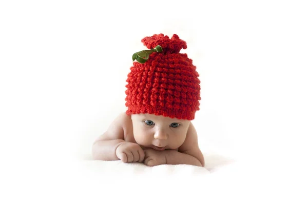 Newborn baby in red berry cap — Stock Photo, Image