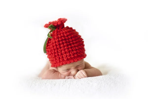 Newborn baby in red berry cap — Stock Photo, Image