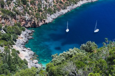 Two sailboats in idyllic small bay clipart