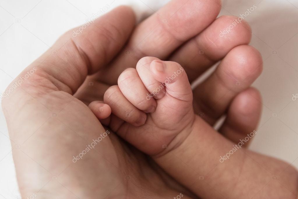 Newborn´s fist in palm of his parent