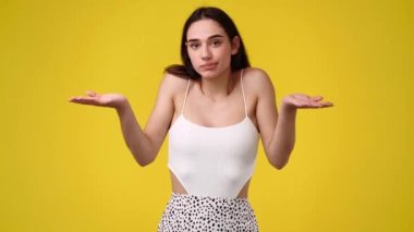 4k video of confused woman over yellow background. Concept of not knowing something.