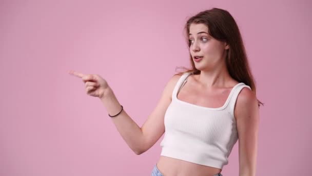 Video Van Mooi Meisje Wijzen Naar Iets Roze Achtergrond Begrip — Stockvideo