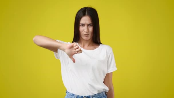 Discontent Woman Shows Diapproval Sign Keeps Thumb Isolated Yellow Background — Stock Video