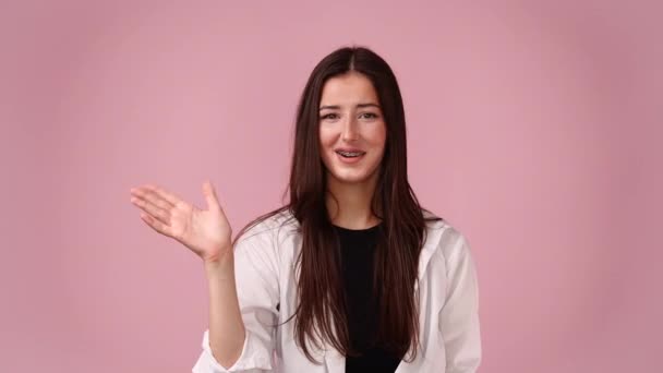 Video Mujer Joven Que Presenta Algo Sobre Fondo Rosa Concepto — Vídeos de Stock