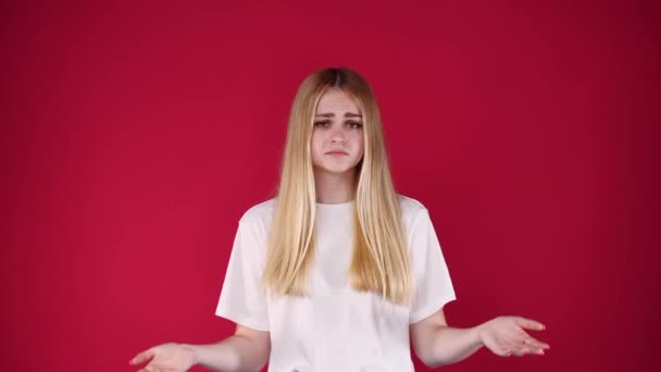 Vídeo Mujer Desconcertada Encogiéndose Hombros Sobre Fondo Rojo Concepto Dudas — Vídeo de stock