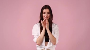 Pembe arka planda ilham verici bir şeyler planlayan genç bir kadının 4K videosu. Düşünce kavramı.